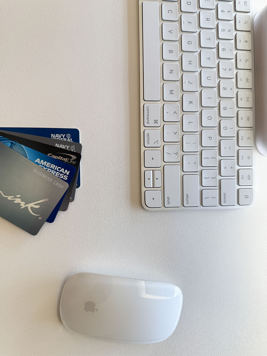 Minimalist white workspace with Apple keyboard, Magic Mouse, and headphones — Beauty Brand Haus web design workflow setup.